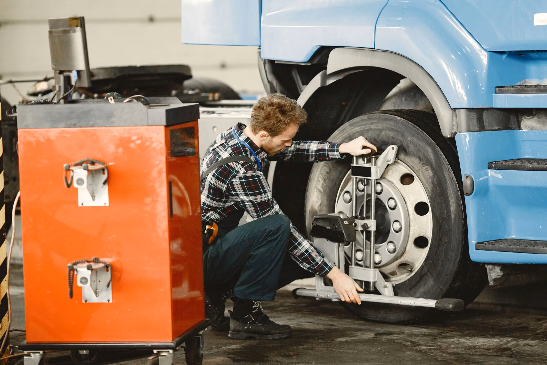 Technician servicing the front wheel of a commercial truck